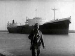 B/W 1956 soldier walking on shore with freighter in Suez Canal in background / Suez Crisis / newsreel Stock Footage