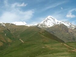 WS PAN View of Caucasus mountains valley and snowy peak / Stepantsminda, Kazbegi, Georgia Stock Footage