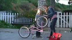 MS Mother helping her daughter how to fix a bicycle Stock Footage
