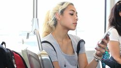 Teenage girls standing on train texting Stock Footage