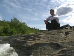 Business man sits at waterfalls Stock Footage