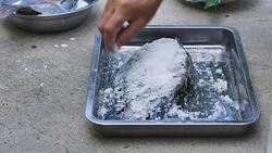 Cooking fish coating with salt Stock Footage
