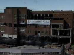 WS Large brick building is demolished in controlled implosion using explosives and dissappears in  huge cloud of dust  / Newcastle upon Tyne, North East England, UK Stock Footage