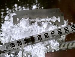 CU SLO MO Drug powder falling on razor blade and syringes against black background / Vieux Pont, Normandy, France Stock Footage