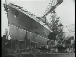 Dockyard with a steel built ship in dock; fixing huge steel plates, UK 1939 Stock Footage