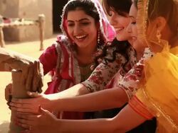 Three young women making pot with a potter on a pottery wheel, Haryana, India Stock Footage