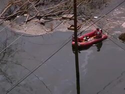 Aerial rescuers in dinghy steering around debris in flooded Gentilly subdivision / New Orleans, low angle Stock Footage