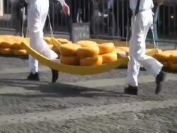 Men carrying large cheese rounds in historical cheese market, Alkmaar, Holland Stock Footage
