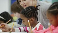 Teacher works with her elementary school students in class Stock Footage