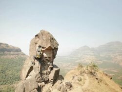 Young man climbing a cliff of mountain  Stock Footage