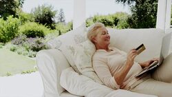 Happy senior woman shopping online on patio sofa Stock Footage