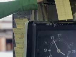 Hispanic worker putting time card into time clock Stock Footage