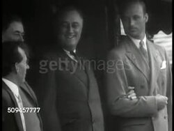 1933: U.S. PRESIDENT FDR TRAVELING: EXT MS Franklin Roosevelt standing w/ assistant at train entrance, reporting asking (SOT) 'when are you coming back?' FDR answering 'Just as soon as Congress will let me,' laughing. Instructional Video