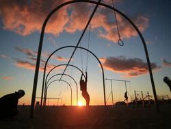 MS SLO MO Man swinging on rings at sunset / Santa Monica, California, United States Stock Footage