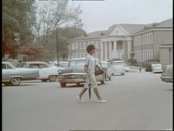 African-American Vivian Malone, reflecting a civil rights victory,  crosses the street to enter a campus building at the University of Alabama in 1963. Stock Footage