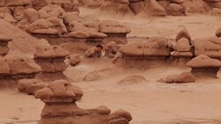 Woman explores giant stone mushrooms Utah's Goblin Valley State Park Stock Footage