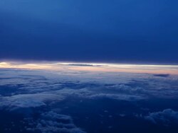 WS AERIAL T/L View of Multiple different types of clouds moving past as we see sun appear on horizon / Hanoi, In Flight Stock Footage