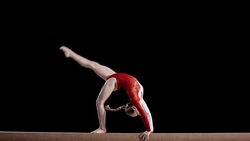 SLO MO Gymnast performing back walkover on balance beam Stock Footage