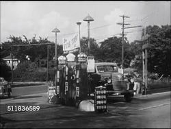 1947: USA OIL ECONOMY: COMMERCIAL FUEL: Greyhound Bus moving on two lane roadway. PERSONAL FUEL: 1946 Ford convertible car pulling into gas station as 'Standard' Oil (Indiana) delivery tank truck pulling out BG, gas station attendant walking to car. Instructional Video