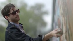 Graffiti artist spraypaints design on urban wall Stock Footage