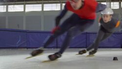 MS SLO MO Short track speed skaters in turn during race on track in arena Stock Footage