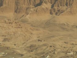 Wide Shot, aerial - Sandstone cliffs surround a town in the Egyptian desert Stock Footage