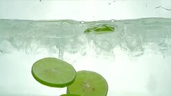 Lime slices drop in the ice water. Close up. Slow motion. Stock Footage