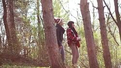Adorable long brown-haired young woman discussing with her charming handsome short-haired friend while taking a long walk Stock Footage