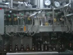 MS Shot of Brown glass beer bottles moving along conveyor and being picked up by machine / Wau, Western Bahr el Ghazal, Sudan  Stock Footage