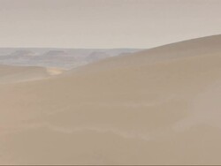 Wide Shot, pan-right - Sand blows off large sand dunes in the Sahara Desert in Egypt Stock Footage