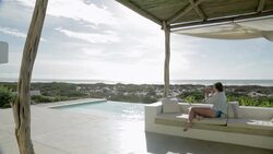 Woman photographing view on luxury patio overlooking ocean Stock Footage