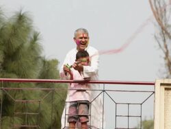 Senior man playing holi festival with his grandson at roof top  Stock Footage