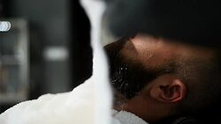 Close-up of beautiful attractive adult man with beard in a barber shop Stock Footage
