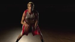 A basketball player displays his dribbling technique at center court of a gymnasium. Stock Footage