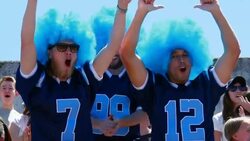 MS Three men wearing football team jerseys and wigs cheering for team in stadium stands Stock Footage