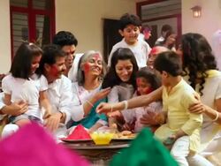 Family celebrating holi festival in the lawn  Stock Footage