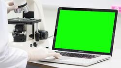 Scientist is using with microscope and green screen laptop Stock Footage
