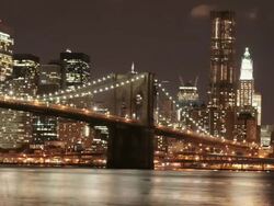WS T/L View of Brooklyn Bridge over river and skyline at night / New York City, New York, USA. Stock Footage