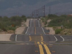 Looking down long straight road across Sonoran Desert, Arizona, USA. Stock Footage