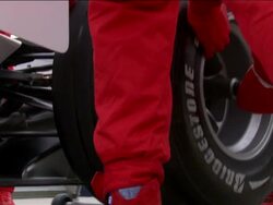 Low angle close up rear tire of Formula One race car being changed by pit crew Stock Footage