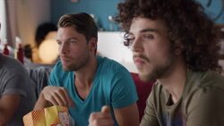 Guys sitting on couch watching tv Stock Footage