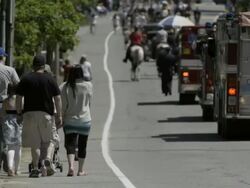Parade in small town with long row of antique cas, flags, boy scounts, military, marching band, and crowds. Smalltown Americana - 2. Stock Footage