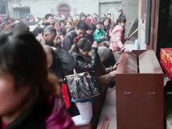 MS Pilgrims praying for good luck and putting money into donation box during Chinese Lunar New Year at Taoist temple / xi'an, shaanxi, china Stock Footage