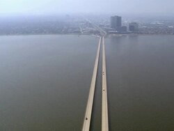 Aerial light traffic across causeway over Lake Pontchartrain to city/ New Orleans, Louisiana Stock Footage