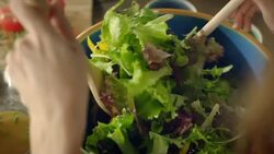 Woman preparing salad for dinner Stock Footage