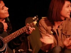 Young woman playing guitar with her friends in the forest, Delhi, India Stock Footage