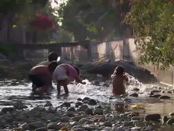 "Slow motion mid of young children splashing water up in the air, bright sunlight lighting up the droplets, rural villiage, Leimebamba [Leymebamba] Valley, Peru" Stock Footage