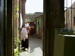 MS PAN Shot of family life in small apartment, women removing dried clothes from rope / Cairo, Egypt Stock Footage