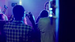 Medium dolly shot of lead guitar through party crowd using cellphones Stock Footage