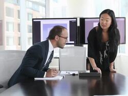 MS R/F businesswoman and businessman in discussion at conference room table looking at digital tablet/Seattle, Washington, USA Stock Footage